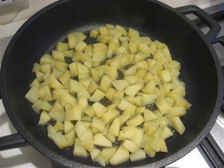 Inbiondire uno spicchio d'aglio in padella con l'olio e poi versarci le patate.