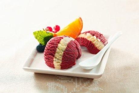 14452864-serving-of-tropical-berry-ice-cream-dessert-with-a-colourful-white-stripe-and-fresh-orange-and-redcu