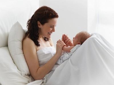 Woman playing with newborn