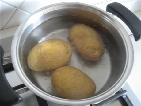 In una pentola far bollire l'acqua, quindi tuffarci le patate con la loro buccia e cuocerle per 10 minuti, scolarle e farle raffreddare.