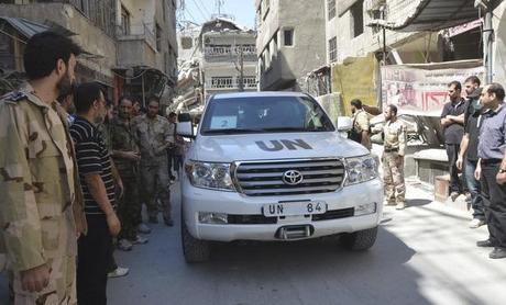 Free Syrian Army fighters and residents gather around a convoy of U.N. vehicles carrying a team of U.N. chemical weapons experts at one of the sites of an alleged chemical weapons attack in Zamalka