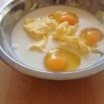 Aggiungere al preparato 3 uova a temperatura ambiente, il burro morbido in pezzi e il latte.