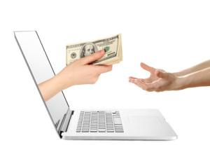 Hand giving money from laptop screen isolated on white