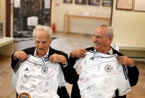 Peter Erben e Zvi Cohen, due sopravvissuti all'olocausto, mostrano le maglie che il presidente della federcalcio tedesca gli ha regalato nel corso delle commemorazioni per le vittime del ghetto di Theresienstadt.