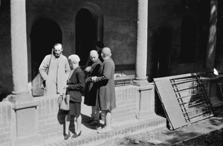 Via San Gregorio, nel chiostro del Lazzaretto, tre donne accusate di collaborazionismo rasate a zero e sorvegliate da un partigiano armato di moschetto.