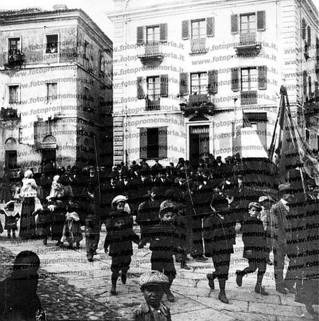 Nuoro, 1911. I lavoratori della Società Operaia, seguiti dalle loro famiglie, sfilano in corteo per le vie della città.