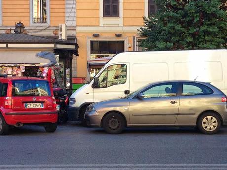 Piazza Cola di Rienzo. Furgoni che fanno da magazzino per le bancarelle (sulle strisce pedonali) e altre storie