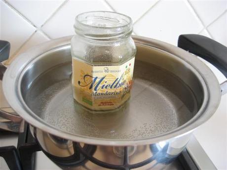 Immergere il barattolo di miele per circa 5 minuti in acqua calda. Girare il miele con un cucchiaino, questo permetterà di velocizzare la fluidificazione.