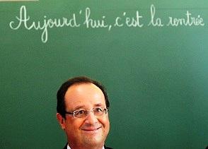 French President Francois Hollande smiles as he sits to chair a round table discussion on the changes in the school timetable set out by the government during a visit to Michelet school in Denain on September 3, 2013. 'Today, it's back to school' is written on the board.  AFP PHOTO / POOL / DENIS CHARLET        (Photo credit should read DENIS CHARLET/AFP/Getty Images)