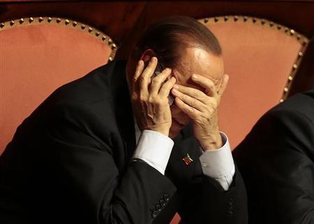 Italian center-right leader Silvio Berlusconi uses a mobile phone during a confidence vote at the Senate in Rome, October 2, 2013. REUTERS/Tony Gentile=/Files