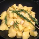 Tagliare le patate a cubetti e versarle in una teglia insieme al aglio, al rosmarino e al sale.