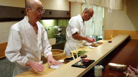     Jiro Ono, 85 anni, il più grande maestro di sushi al mondo, nella cucina del suo ristorante di Tokyo con il figlio.