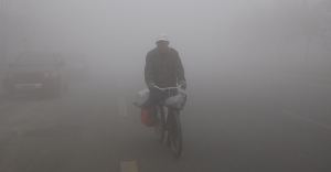 Un uomo sulla sua bicicletta nello smog di Harbin, in Cina (framework.latimes.com)