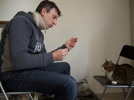 Foto che mi ritrarae seduto di profilo su una sedia con di fronte un'altra sedia con seduto sopra il mio gatto Peppino e io ci parlo utilizzando il counseling come fosse un cliente