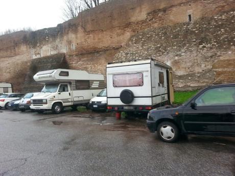 Tutto sulla roulottizzazione di Piazzale Ostiense. Ormai ogni posto macchina può diventare un appartamento, basta essere a Roma (dove nessuno ti farà mai niente) e avere un camper sgangherato. Puoi metterti anche di fronte alle mura aureliane