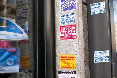 TRASLOCATORI, SERRANDARI, SPURGO FOGNE: IL DEGRADO VISIVO DEGLI STICKERS A CUI PROPRIO NON SI RIESCE A PORRE RIMEDIO. SGUAZZANO E MAGNANO NELL'ILLEGALITA'