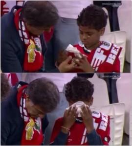 Un piccolo tifoso del Benfica in lacrime, il genitore gli porge un fazzoletto. Quanto fa soffrire la maledizione di Guttman.