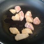 Infarinare i bocconcini di pollo, setacciando l'eccesso di farina e soffriggere in un filo d'olio.