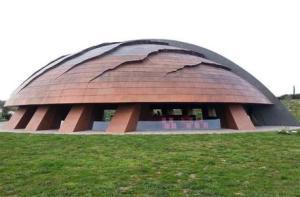 La cantina è un’enorme cupola rivestita di rame, contrassegnata con un modello di solchi e fessure che ricordano la natura dei terreni circostanti