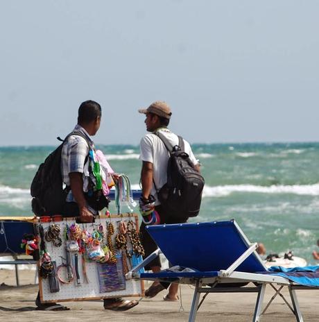L'esercito, gestito dalla Camorra, dei venditori abusivi sulle spiagge di Ostia. Uno ogni 30 secondi per rendere impossibile anche qualche ora di relax al mare