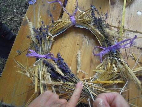 Piccole e grandi mani al lavoro con paglia di segale, lavanda e...