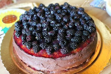 Una soffice torta farcita con crema al cioccolato e guarnita con more di rovo