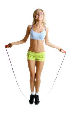 Beautiful sportsgirl with skipping rope isolated on white