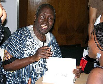 Ngũgĩ wa Thiong'o signs copies of his new book...