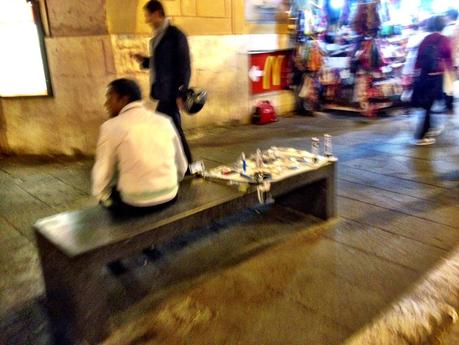 Via Nazionale di sanpietrini o di asfalto? Intanto non c'è più una panchina libera dagli ambulanti abusivi e trasformata in bancarella