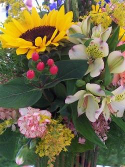 Composizione con girasoli, orchidee e bacche