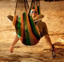 Man relaxing in a hammock on the sandy beaches of The Bahamas Man relaxing in a hammock on the sandy beaches of The Bahamas