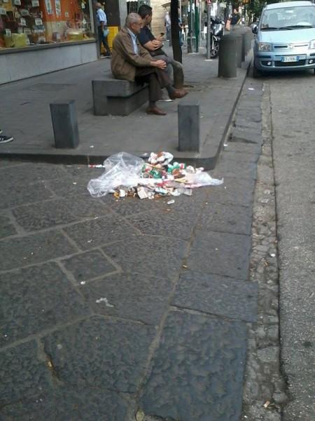 Spazzatura ammucchiata e non raccolta lungo il ciglio di un marciapiede al corso Secondigliano.