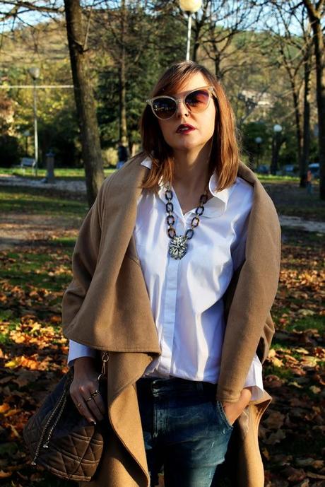 Outfit: cappotto beige, camicia bianca e borsa a secchiello