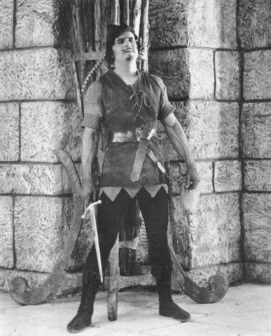 Fairbanks_Robin_Hood_standing_by_wall_w_sword