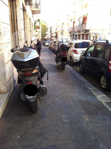 Forse è il caso di piantarla di posteggiare i motorini sul marciapiede? Forse è il caso di iniziare a multare seriamente questa infrazione?