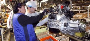 Employees work on a motor assembly line