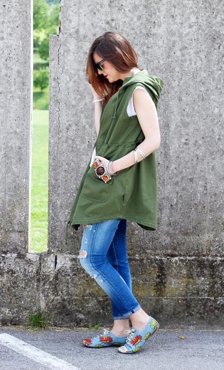 Outfit: Parka verde smanicato, ripped jeans e scarpe oxford con stampa fumetto