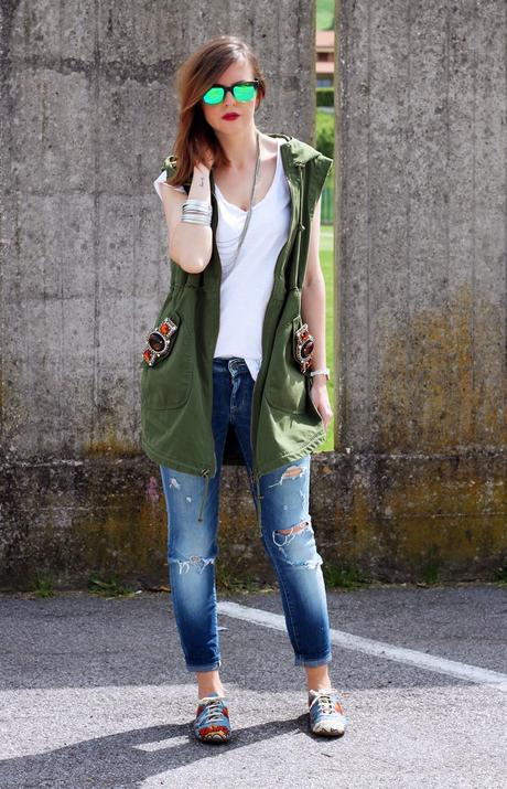 Outfit: Parka verde smanicato, ripped jeans e scarpe oxford con stampa fumetto