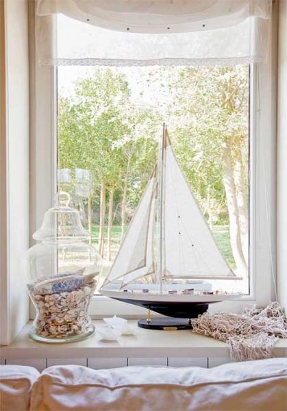 Na parapecie urządziła morski zakątek – z żaglówką, muszlami  i rybackimi sieciami. Ma oko do łowienia drobiazgów.