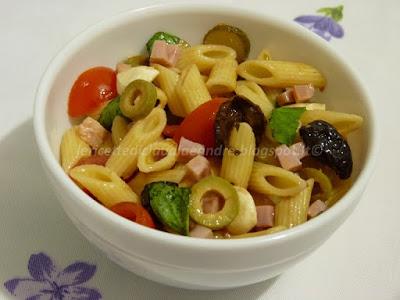 Insalata di pasta fredda con olive, pomodorini, prosciutto e mozzarelline