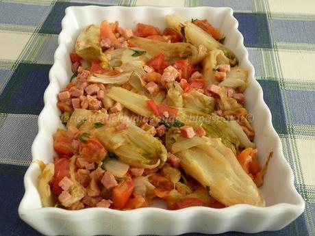 Insalata belga in padella con prosciutto pomodori e profumo di basilico