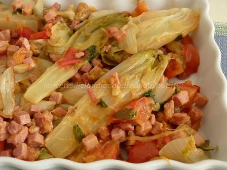 Insalata belga in padella con prosciutto pomodori e profumo di basilico