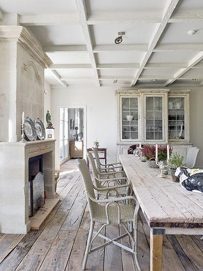 Wokół surowego stołu stoją rattanowe krzesła z Belgii i tapicerowane angielskie. 