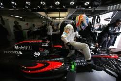 Fernando Alonso climbs from his car in the garage.