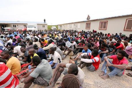 Migrants from sub-Saharan Africa rest inside a detention center in the Libyan capital Tripoli on June 4, 2015. Authorities, acting on a tip off, stormed a hideout where more than 500 illegal migrants, mostly men from African, were waiting for people smugglers to take them to boats to Europe, migration officials in Tripoli said. AFP PHOTO / MAHMUD TURKIA