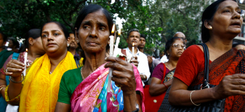 Donne pregano durante una manifestazione contro la violenza sulle donne in India