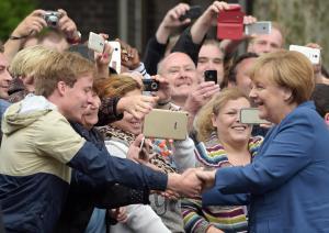 German Chancellor Angela Merkel shakes hands with inhabitants of  Duisburg, Germany,  when she visits  the Duisburg -Marxloh , a neighborhood with a large immigrant population, Tuesday Aug.  25, 2015.  (Federico Gambarini/dpa via AP)