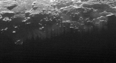 Il sole al tramonto illumina la foschia che ricopre la superficie di Plutone, tagliata dalle ombre delle molte colline e piccole montagne. Credit: NASA/Johns Hopkins University Applied Physics Laboratory/Southwest Research Institute