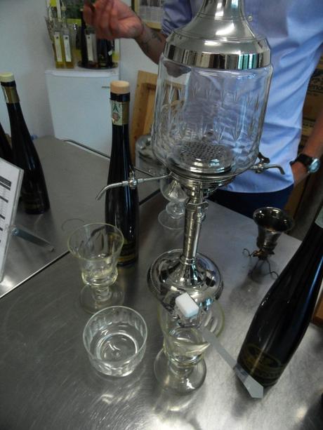 Sul cucchiaino da assenzio viene posata una zolletta di zucchero, su cui si versa l'acqua