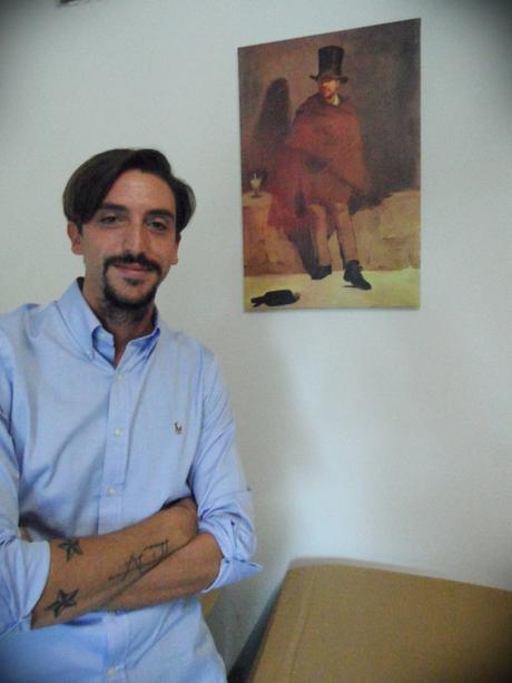 Saverio posa in magazzino con una riproduzione de ''Il bevitore di assenzio'' di Manet